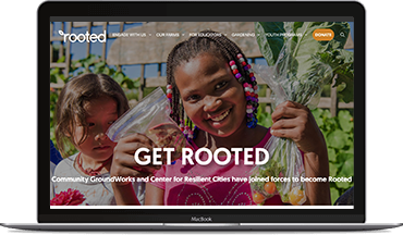 An open laptop showing the home page of of the Rooted website